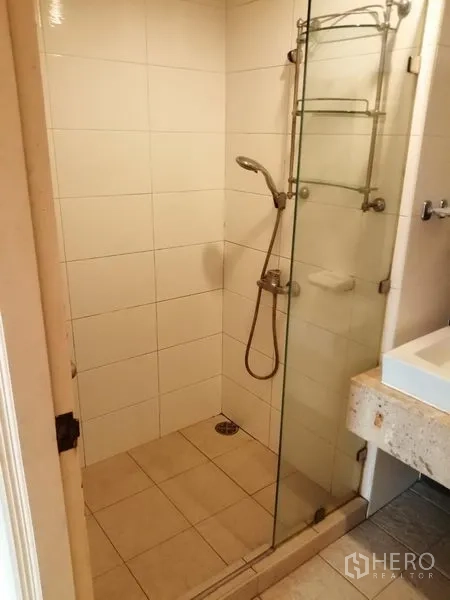 公寓 出租在Watthana, Bangkok - 瓷砖浴室，玻璃淋浴间与台盆。