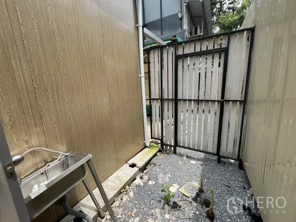 พื้นที่ขายปลีก ให้เช่าในKhlong Toei, Bangkok - มุมเซอร์วิสกลางแจ้งพร้อมอ่างล้างสแตนเลส พื้นโรยหิน และประตูระแนง