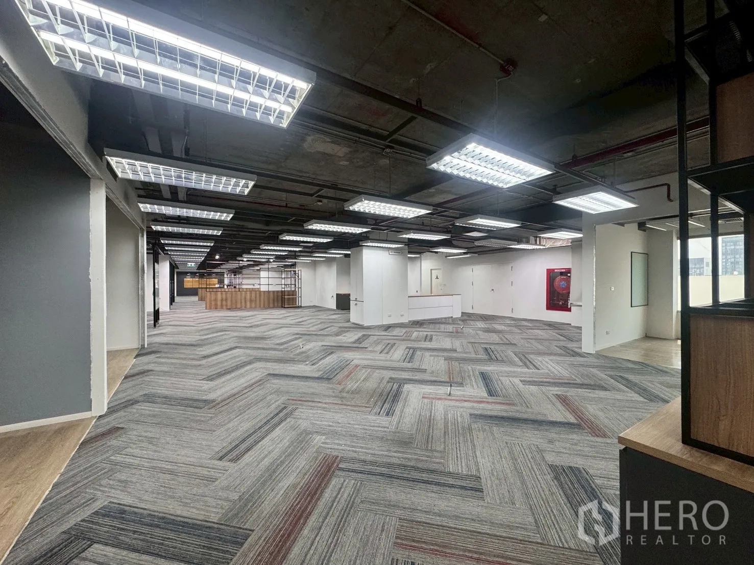 办公室 for rent in Watthana, Bangkok - 宽阔整层空间，明亮荧光灯顶，远端可见白色接待区。