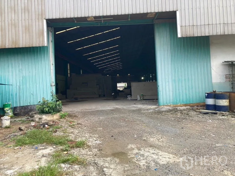 คลังสินค้า ให้เช่าในMueang Samut Sakhon, Samut Sakhon - ทางเข้าโกดังประตูสีเขียวฟ้า มีถังและพื้นที่ลานสำหรับขนถ่ายสินค้า