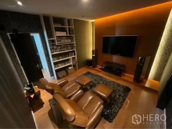 Detached House for sale in Prawet, Bangkok - Cozy media room with leather recliners, wall-mounted TV, speakers and built-in shelving.