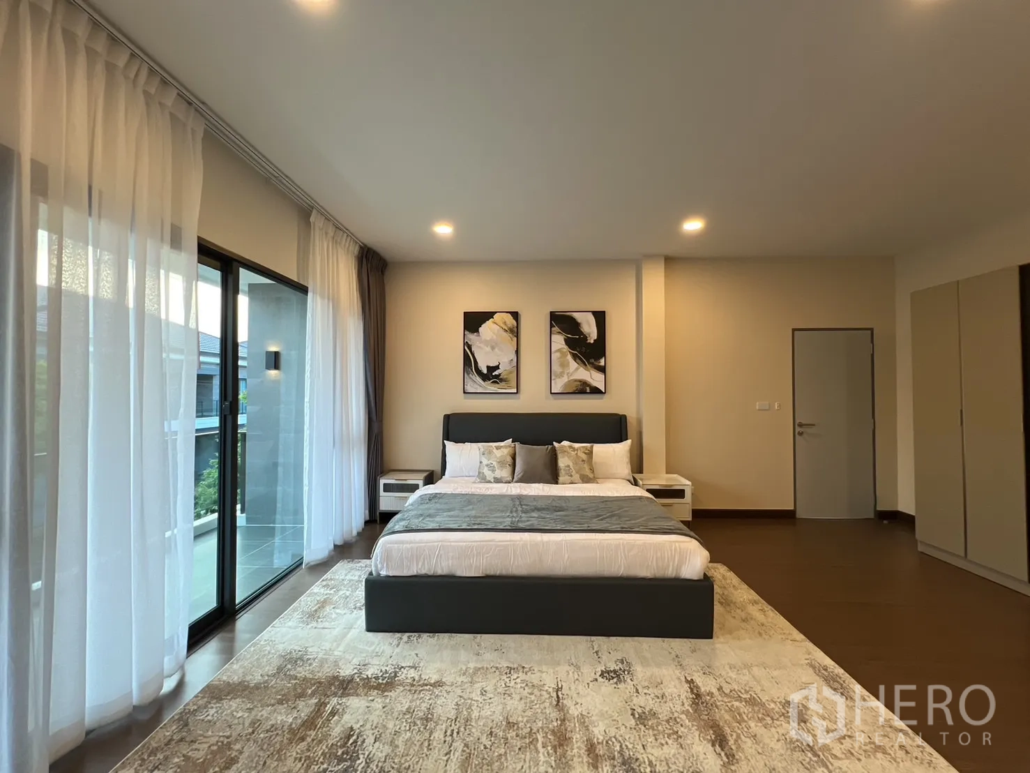 Detached House for rent or sale in Bang Phli, Samut Prakan - Master bedroom facing balcony, sheer curtains and framed artwork.
