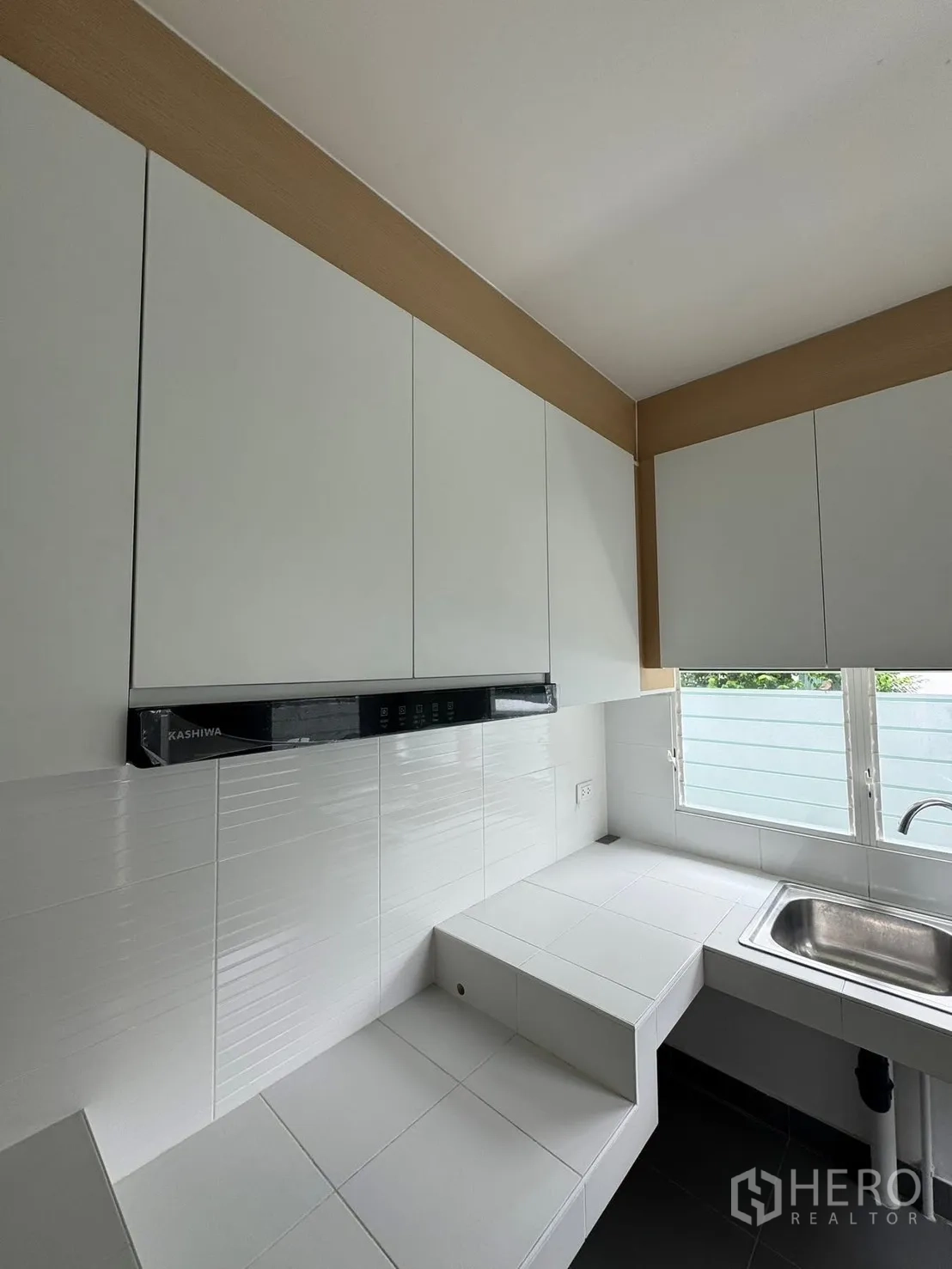 บ้านเดี่ยว for rent in Bang Phli, Samut Prakan - ครัวสว่างด้วยตู้สีขาว เคาน์เตอร์กระเบื้อง และซิงก์ติดหน้าต่าง