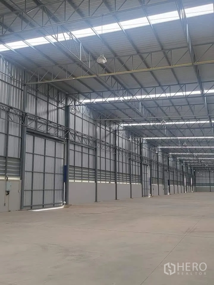 仓库 for rent in Lat Krabang, Bangkok - 仓库侧墙内景，滑动门、通风百叶与开阔作业面。