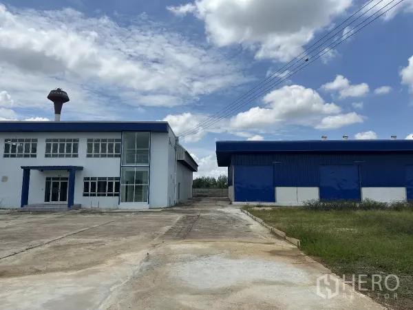 Warehouse for rent in Bang Len, Nakhon Pathom - Front view of blue-roof warehouse with two-storey office and wide concrete yard in Bang Len.