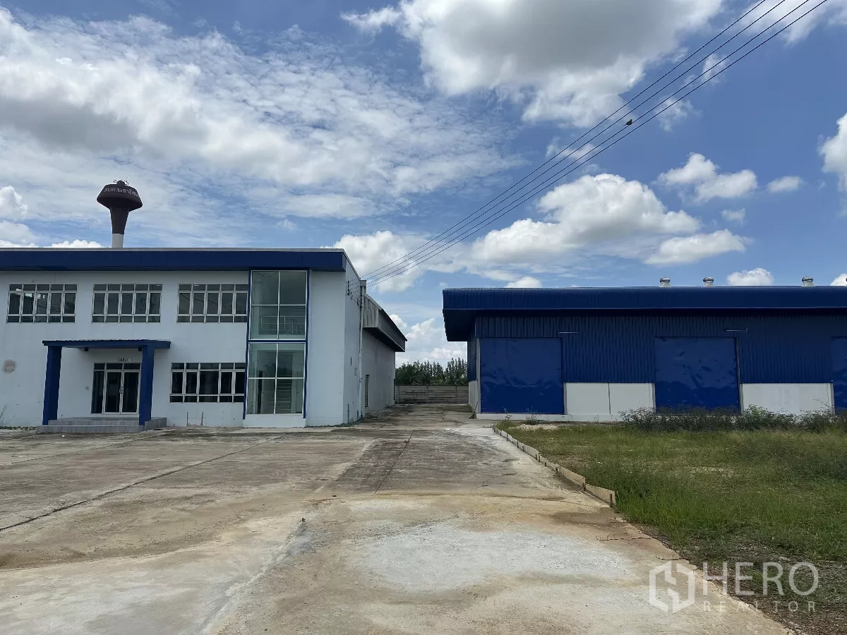 Warehouse for rent in Bang Len, Nakhon Pathom - Front view of blue-roof warehouse with two-storey office and wide concrete yard in Bang Len.