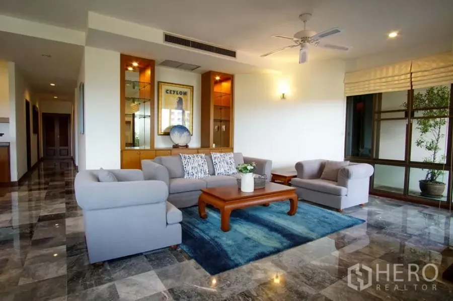 อพาร์ทเมนท์ ให้เช่าในWatthana, Bangkok - ห้องนั่งเล่นสว่าง ชุดโซฟาสีเทา พรมสีน้ำเงิน ตู้โชว์บิลท์อิน และหน้าต่างบานใหญ่