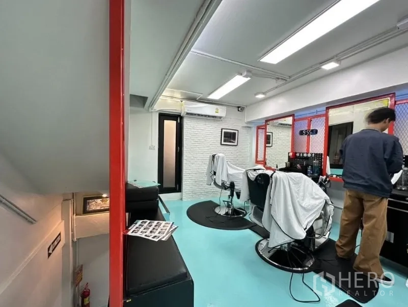 店屋 for sale in Watthana, Bangkok - 室内沙龙风格空间，青绿色地面、镜台与理发椅，线性灯带明亮。