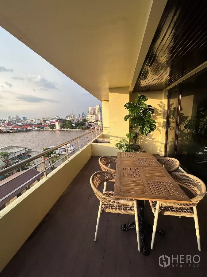 คอนโด ให้เช่าในKhlong San, Bangkok - ระเบียงมีหลังคาพร้อมชุดโต๊ะอาหารหวาย มองเห็นแม่น้ำเจ้าพระยา