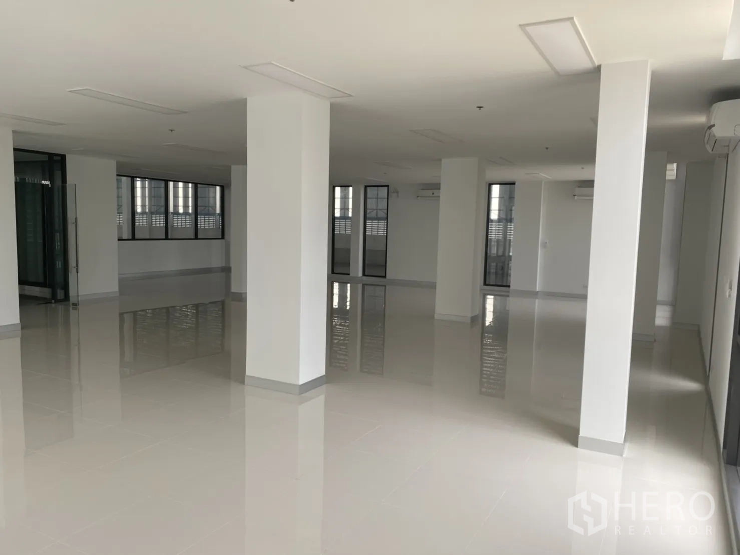Warehouse for rent in Chachoengsao - Large office floorplate with windows and polished tiles inside the warehouse.