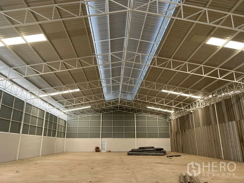 Warehouse for rent in Min Buri, Bangkok - High ceiling warehouse roof with central translucent skylight and white steel framing.