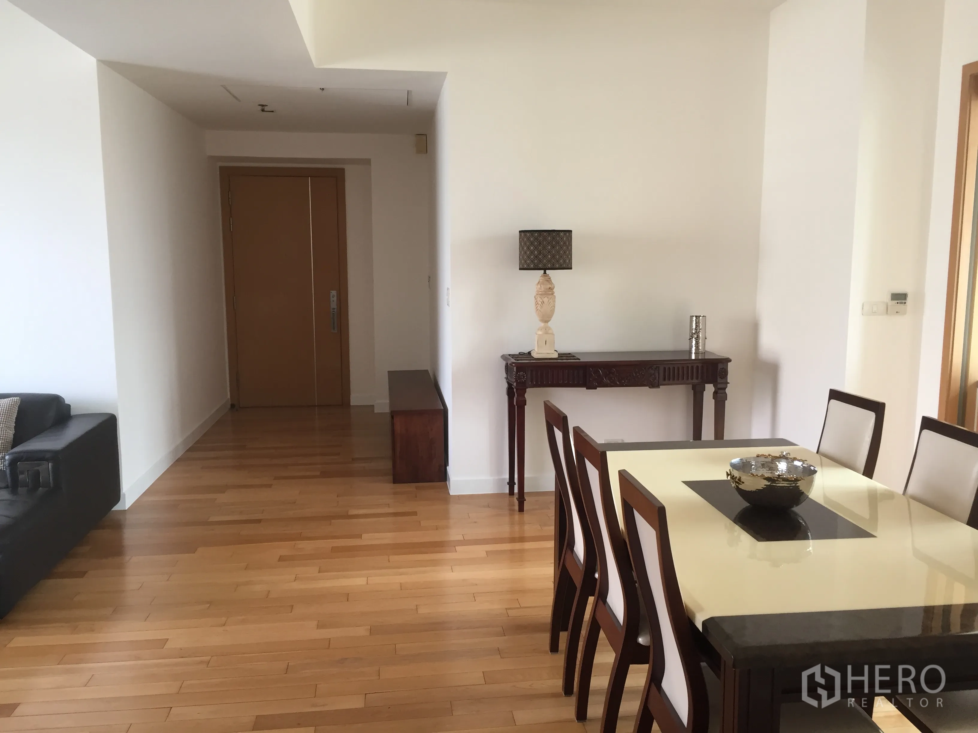 คอนโด ให้เช่าในKhlong Toei, Bangkok - มุมรับประทานอาหารโต๊ะหกที่นั่ง ทางเข้าห้อง และโต๊ะคอนโซลบนพื้นไม้โทนอุ่น