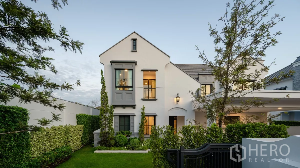 Detached House for rent or sale in Khlong Toei, Bangkok - Modern detached house exterior with gabled roof, carport and landscaped front lawn.