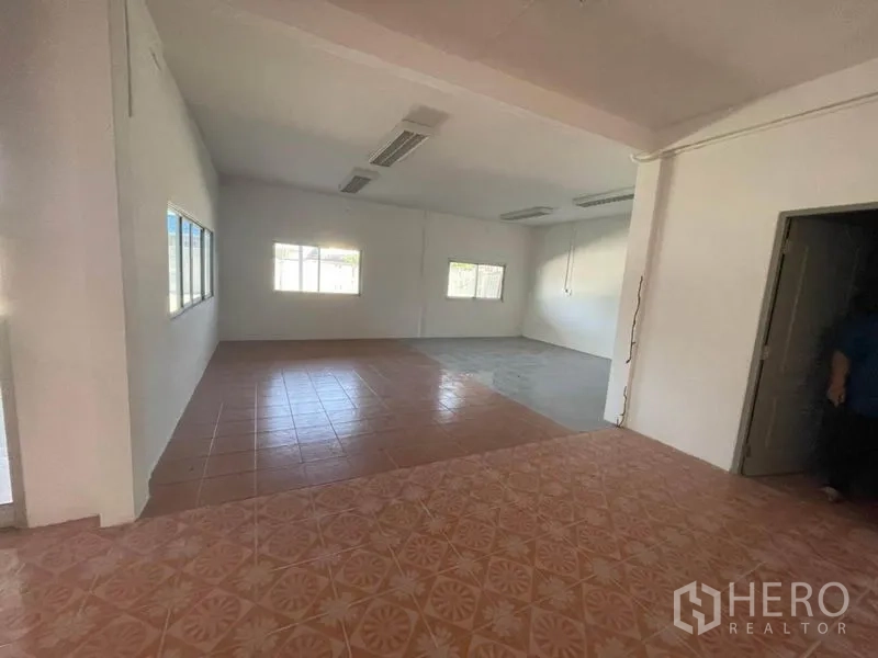 Factory for rent in Sam Khok, Pathum Thani - Flexible office area with mixed tile flooring, white walls and natural light.
