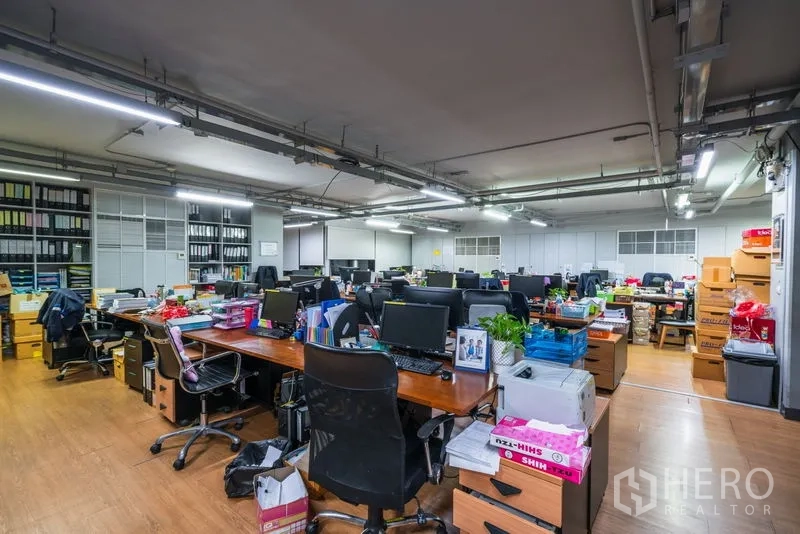 สำนักงาน ให้เช่า - ออฟฟิศกว้างพื้นลายไม้ มีโต๊ะ เก้าอี้ และชั้นแฟ้มจำนวนมาก