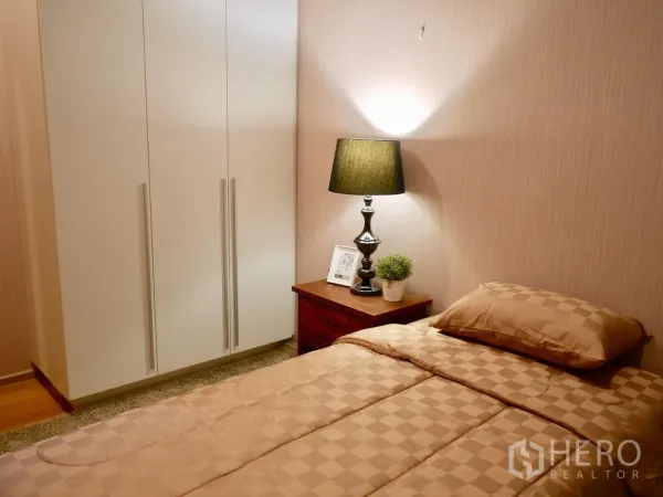 คอนโด ให้เช่าในWatthana, Bangkok - ห้องนอนรอง โทนอบอุ่น ตู้เสื้อผ้า โต๊ะข้างเตียง และแสงไฟนุ่มนวล