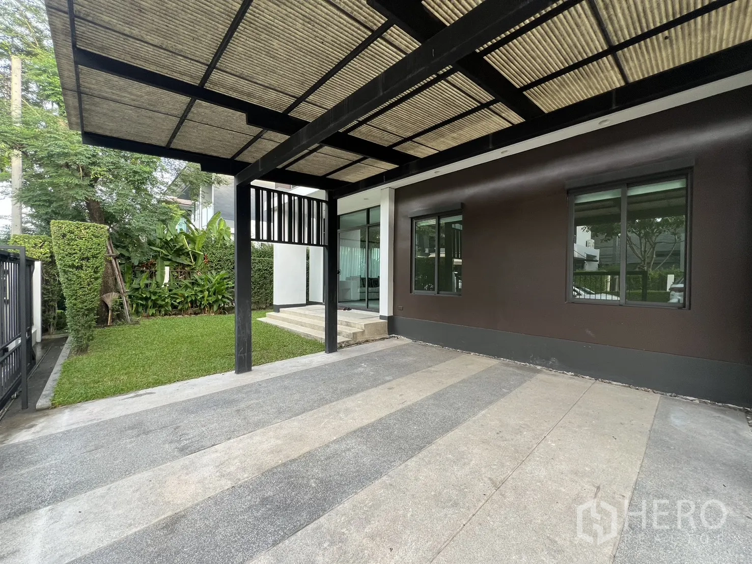 บ้าน ให้เช่าในBang Kapi, Bangkok - โรงจอดรถมีหลังคาข้างสนามหญ้าและบันไดขึ้นบ้าน