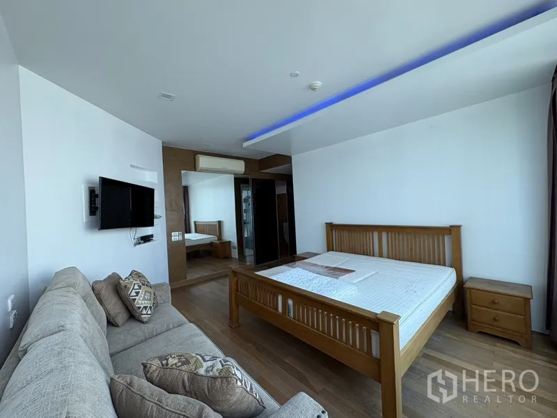 คอนโด for rent in Khlong San, Bangkok - ห้องนอนกว้าง เตียงไม้ โซฟา ทีวี และพื้นไม้ภายใต้ไฟฝังฝ้า