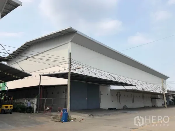 工厂 出租在Bang Bua Thong, Nonthaburi - 高坡屋顶工厂转角视图，设超大进出门。