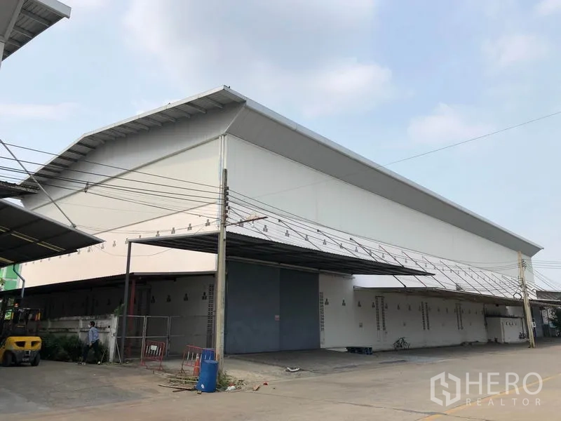 工厂 出租在Bang Bua Thong, Nonthaburi - 高坡屋顶工厂转角视图，设超大进出门。