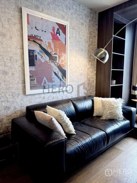 คอนโด ให้เช่า - ภาพระยะใกล้ของโซฟา งานศิลปะ และชั้นวางในห้องนั่งเล่นคอนโด