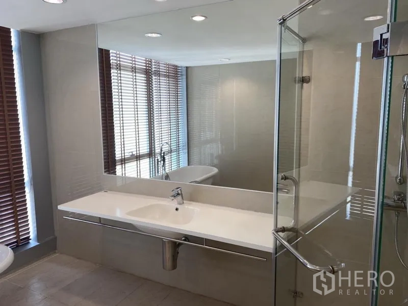 คอนโด ให้เช่าหรือขายในKhlong San, Bangkok - ห้องน้ำสมัยใหม่พร้อมตู้กระจกอาบน้ำ เคาน์เตอร์อ่างล้างหน้า และกระจกบานใหญ่