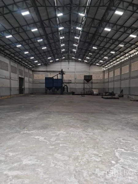 Warehouse for rent in Krathum Baen, Samut Sakhon - Spacious warehouse interior with high steel truss roof, skylights and open concrete floor.