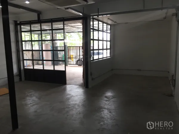 บ้าน ให้เช่าในDin Daeng, Bangkok - ห้องกว้างเปิดสู่ลานด้วยประตูกระจกลายตารางและหน้าต่างด้านข้าง