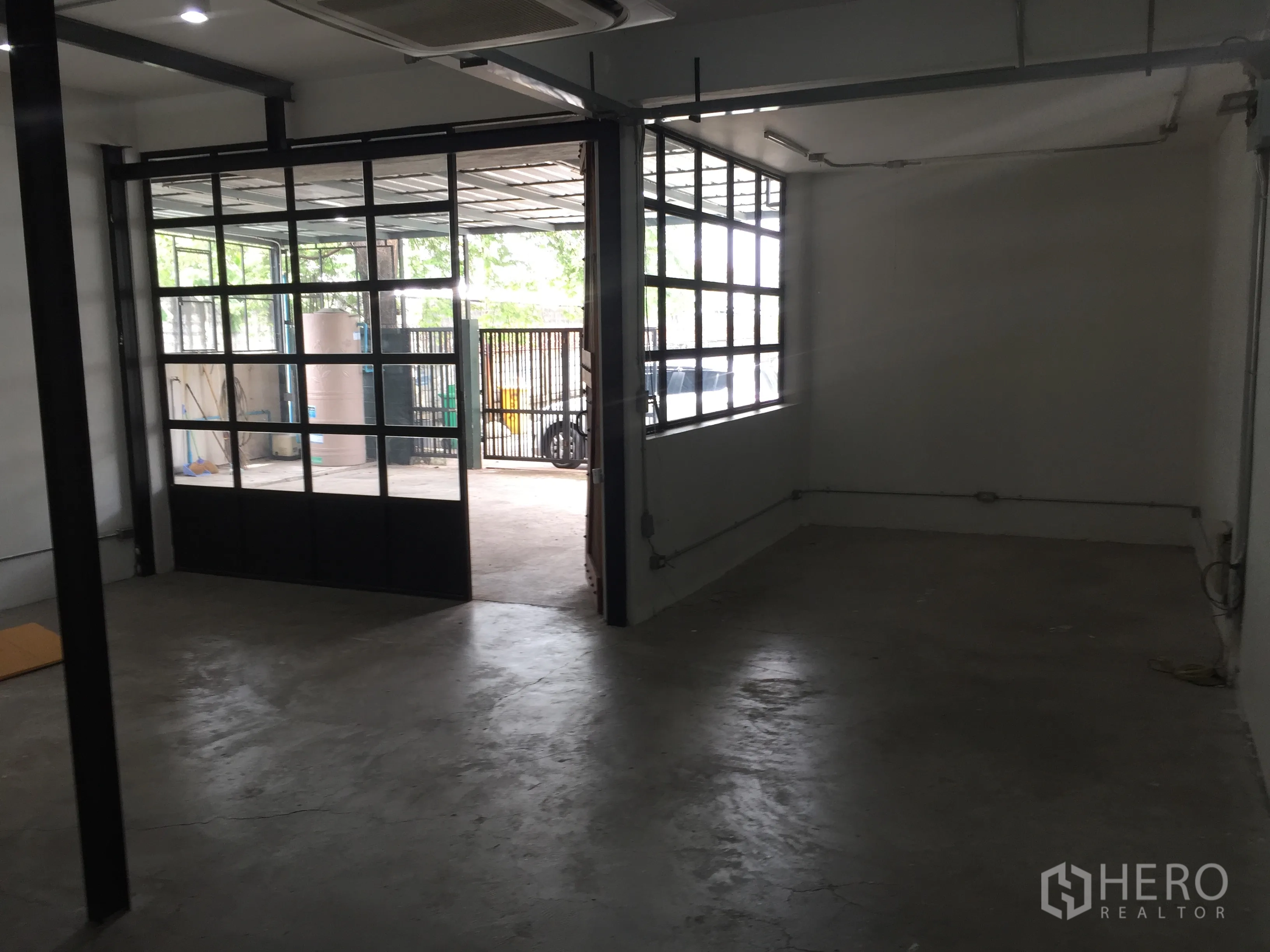 บ้าน ให้เช่าในDin Daeng, Bangkok - ห้องกว้างเปิดสู่ลานด้วยประตูกระจกลายตารางและหน้าต่างด้านข้าง