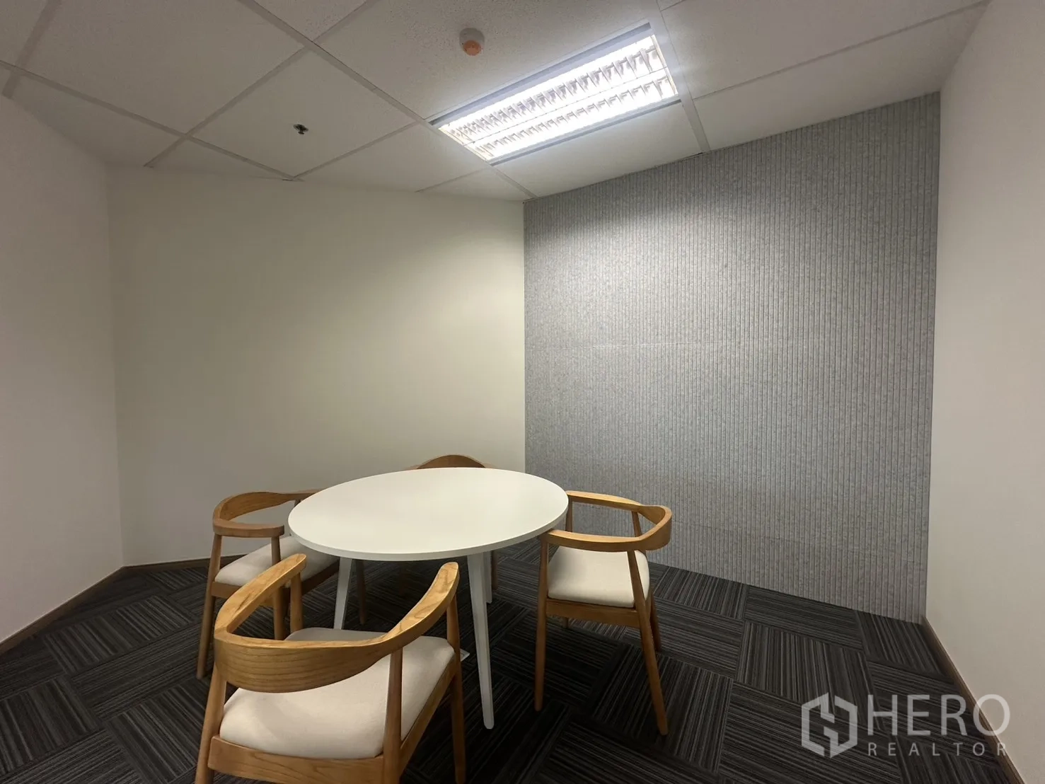 办公室 for rent in Pathum Wan, Bangkok - 封闭式小会议室，圆桌与木椅。