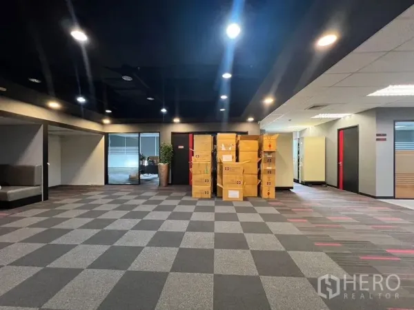 办公空间 出租在Huai Khwang, Bangkok - 宽敞开放式办公室，方格地毯与堆放纸箱，顶置筒灯照明。