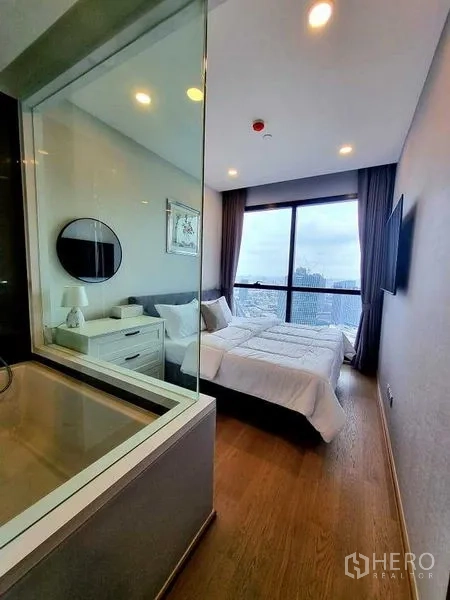 公寓 出租在Bang Rak, Bangkok - 卧室带玻璃墙与浴室相连，设大窗可赏城市景观。