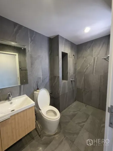 Home Office for rent in Pak Kret, Nonthaburi - Contemporary bathroom fitted with gray tiles, vanity sink and a walk-in shower area.