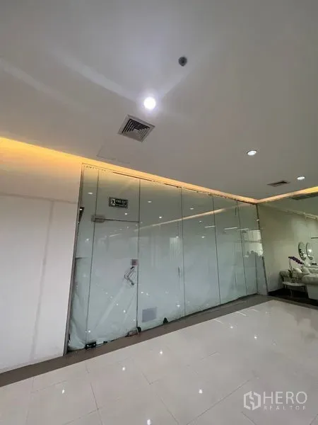 零售空间 出租 - 整面落地玻璃店面与抛光走廊相对，顶面筒灯，适合做门头与橱窗展示。