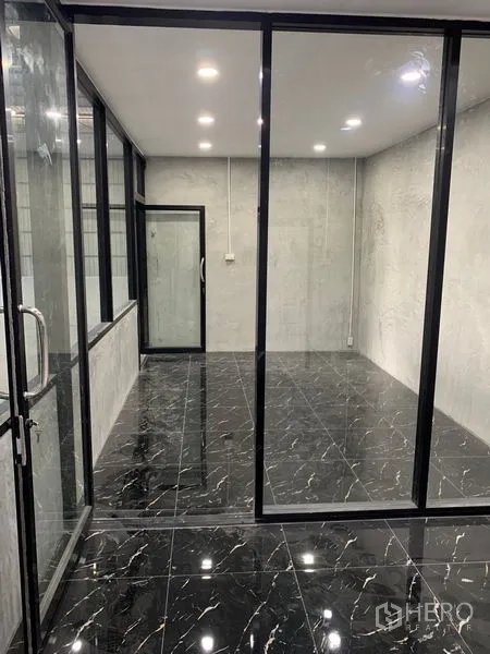 货栈 出租在Khan Na Yao, Bangkok - 玻璃隔断办公室另一视角，亮面地砖与顶灯。