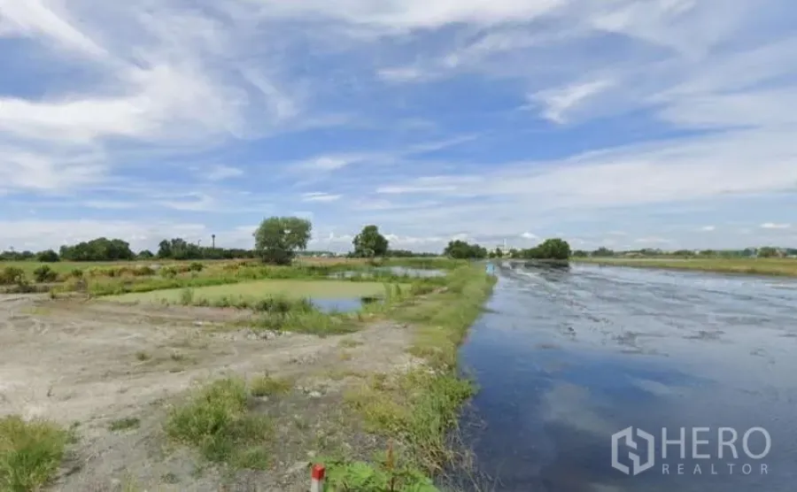 Land for sale in Chachoengsao - Open plot with multiple ponds and embankments in an agricultural setting.