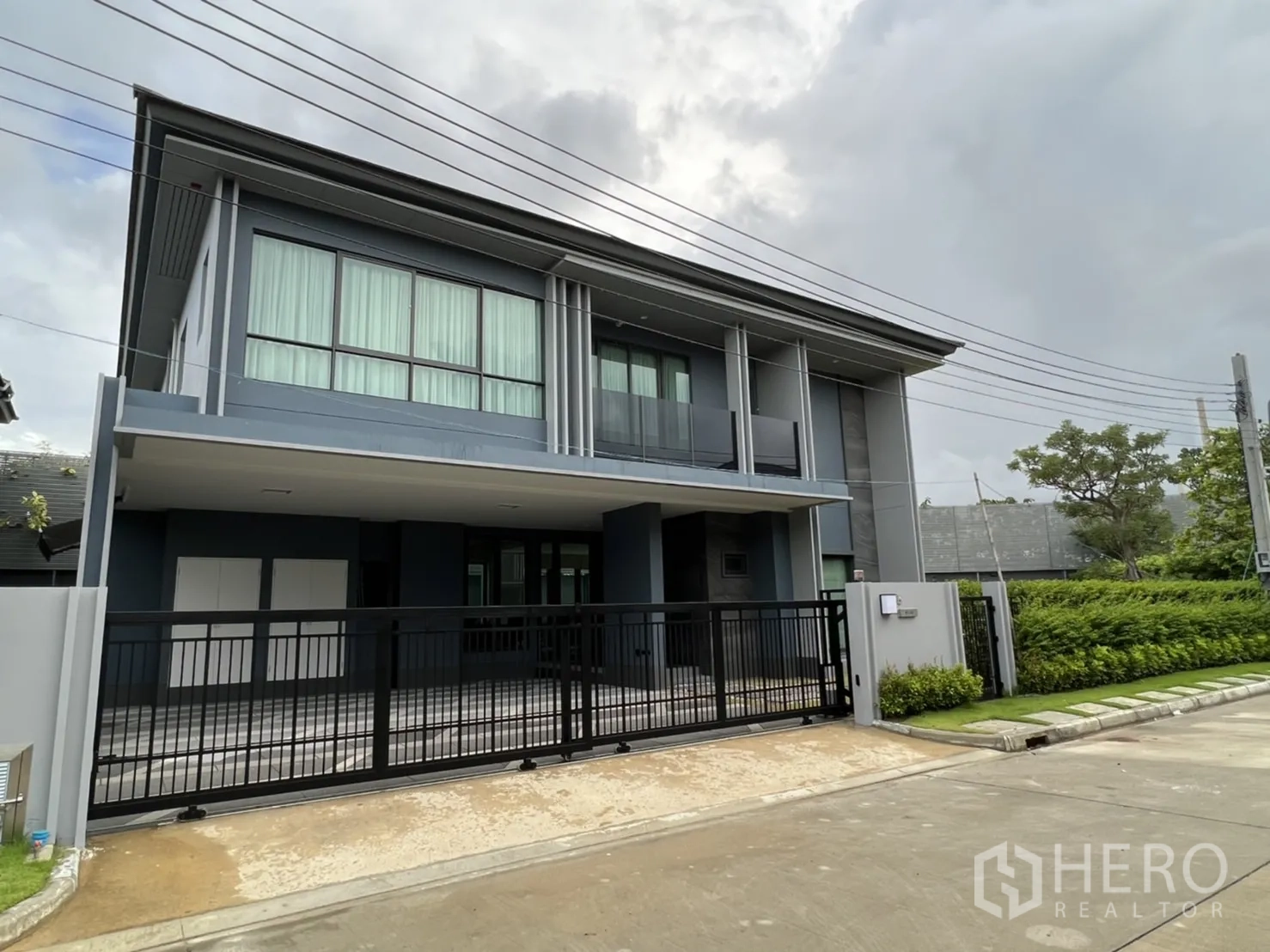 Detached House for rent in Bang Kapi, Bangkok - Modern two-storey detached house with gated entrance and a covered carport.
