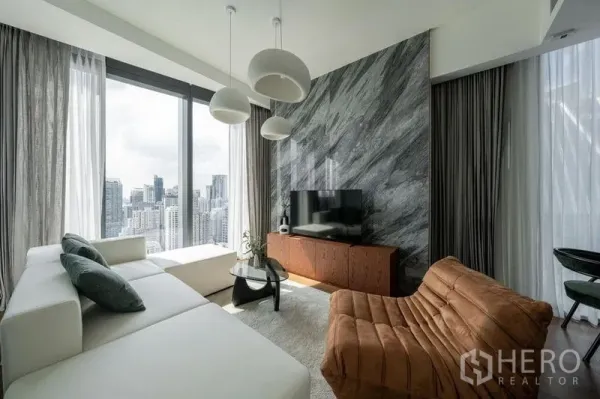 公寓 出租在Khlong Toei, Bangkok - 采光充足的客厅，石纹特色墙与白色沙发，落地窗俯瞰曼谷天际线。