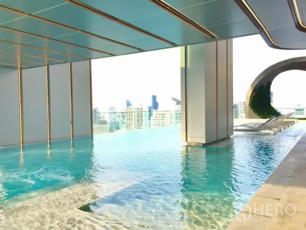 คอนโด ให้เช่าในWatthana, Bangkok - สระว่ายน้ำอินฟินิตี้บนดาดฟ้าพร้อมวิวสกายไลน์และเก้าอี้อาบแดดของคอนโดโมเดิร์น