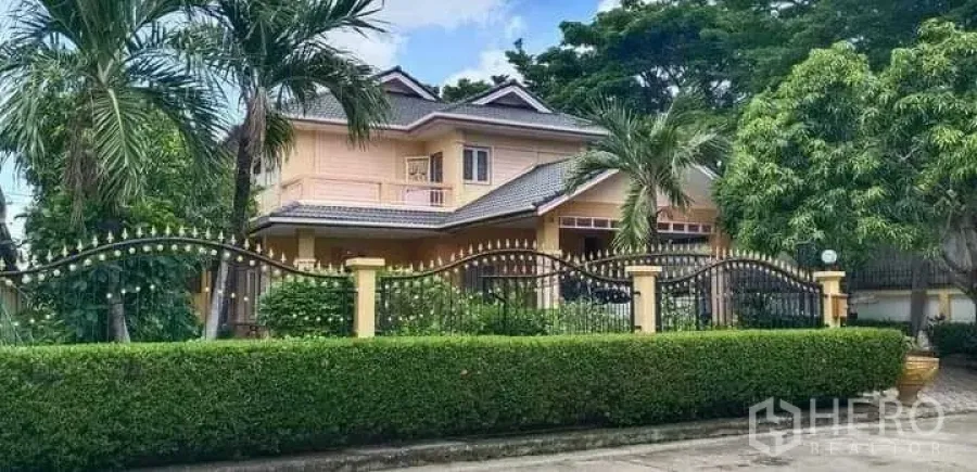 บ้าน ขายในPrawet, Bangkok - มุมมองจากถนนของบ้าน พร้อมรั้วเหล็กดัด ต้นปาล์ม และสวนร่มรื่น