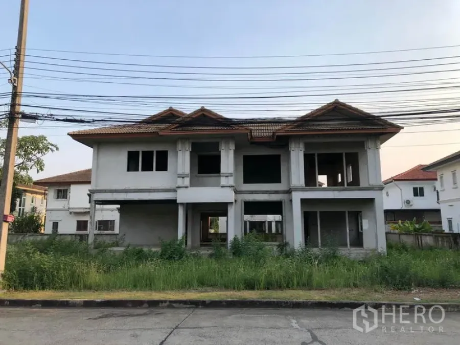 บ้าน ขายในLam Luk Ka, Pathum Thani - ด้านหน้าบ้านเดี่ยวสองชั้นก่อสร้างไม่เสร็จ หลังคากระเบื้อง สนามหญ้ารก ในลำลูกกา ปทุมธานี