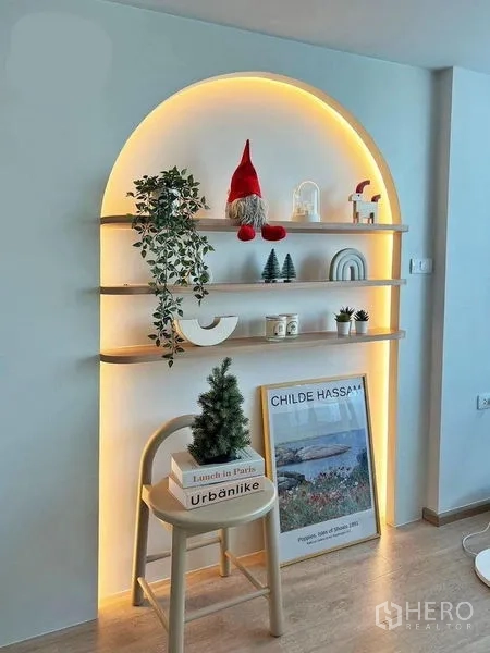 คอนโด ให้เช่าในHuai Khwang, Bangkok - ชั้นโชว์ทรงโค้งพร้อมไฟซ่อนโทนอุ่น ตกแต่งต้นไม้และงานศิลป์ ในพื้นที่นั่งเล่นคอนโดสมัยใหม่