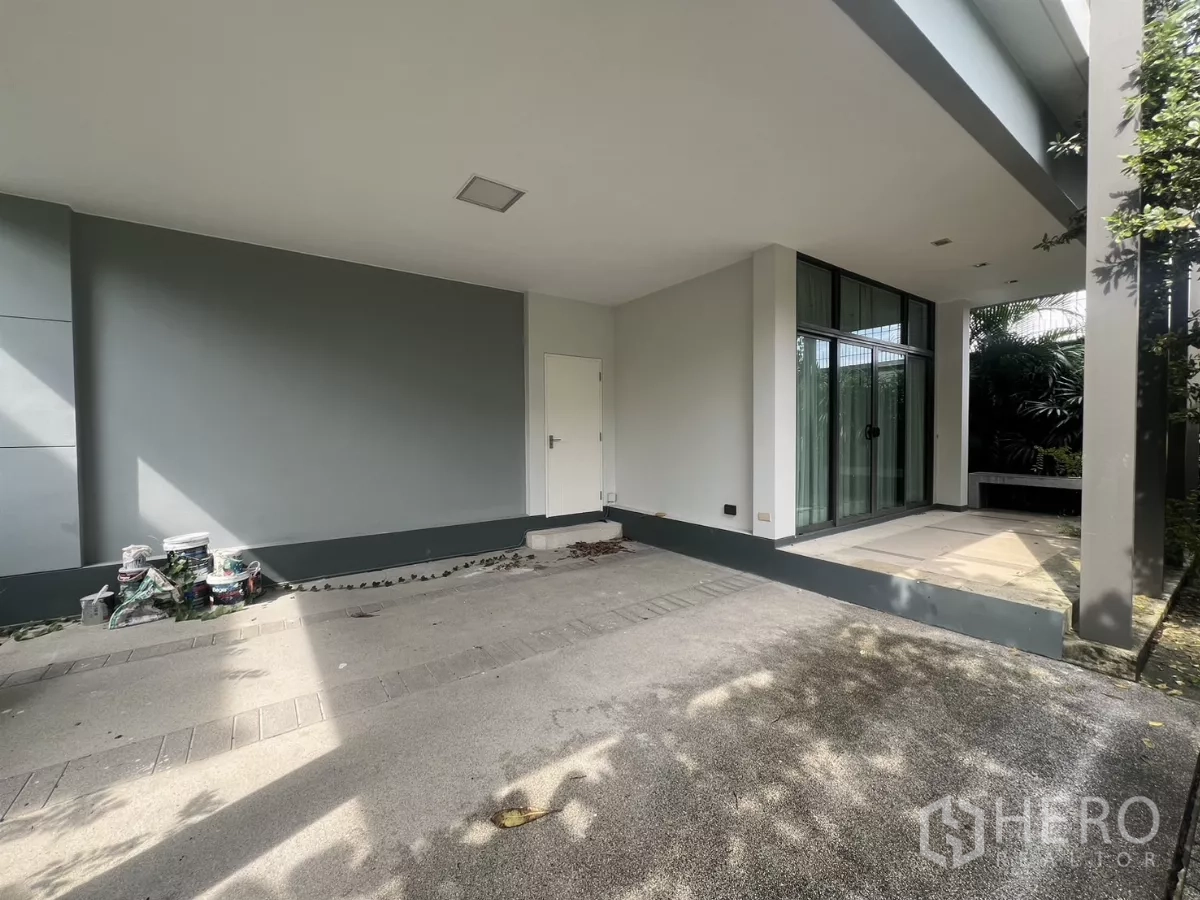 Detached House for sale in Bang Kapi, Bangkok - Covered two-car carport with side terrace and sliding glass doors to the house.