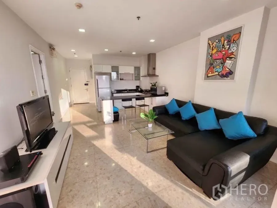 Condominium for rent in Khlong Toei, Bangkok - Bright open living space with TV unit, tiled floor and kitchen with breakfast bar.