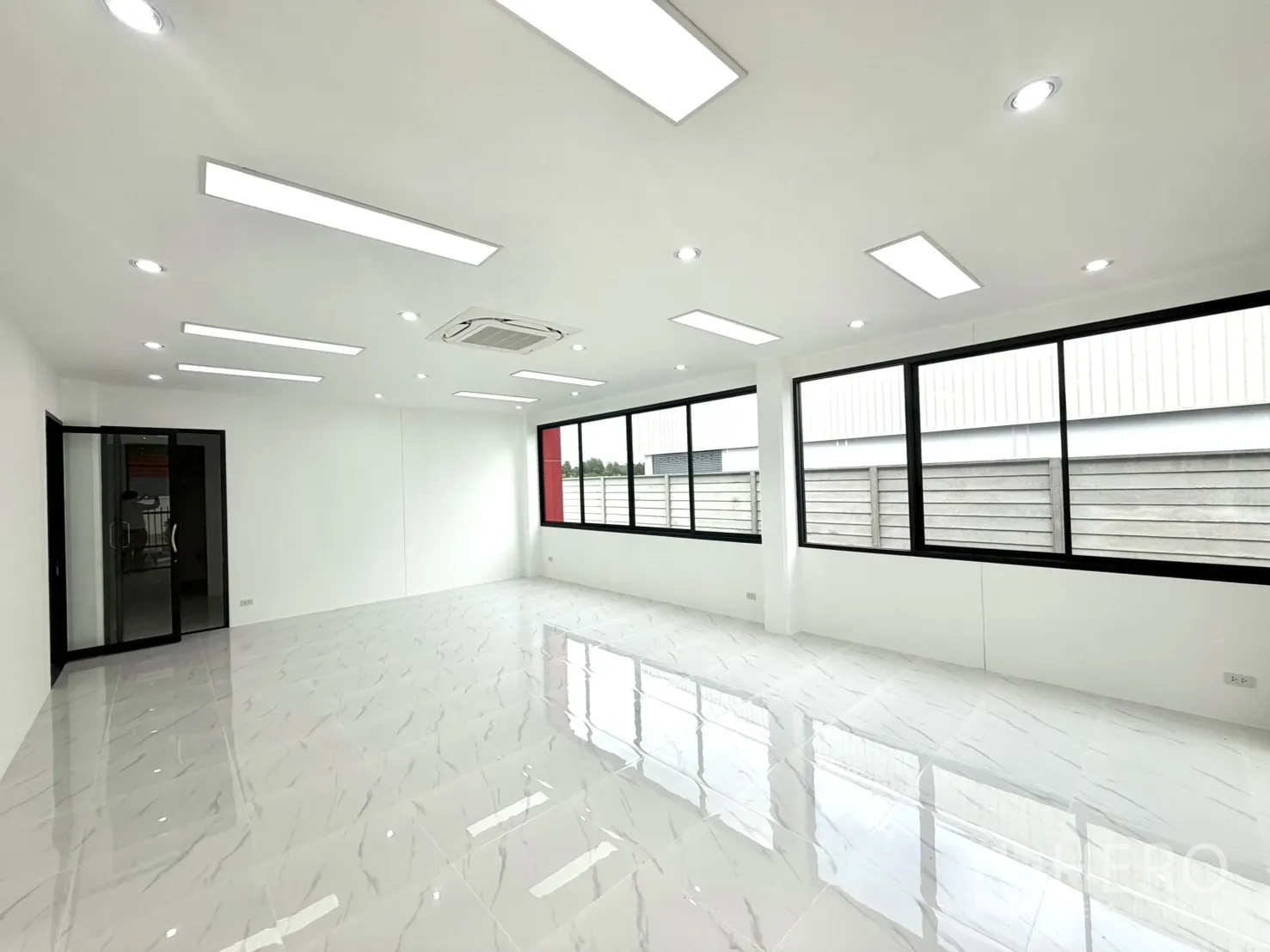 Factory for rent or sale in Lam Luk Ka, Pathum Thani - Bright office room with tiled floor, ceiling lights, and an air conditioner.