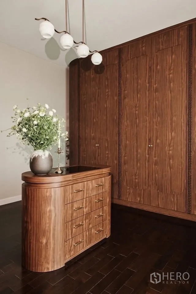 Detached House for rent or sale in Lat Krabang, Bangkok - Closet island dresser with flowers beneath a contemporary pendant light.