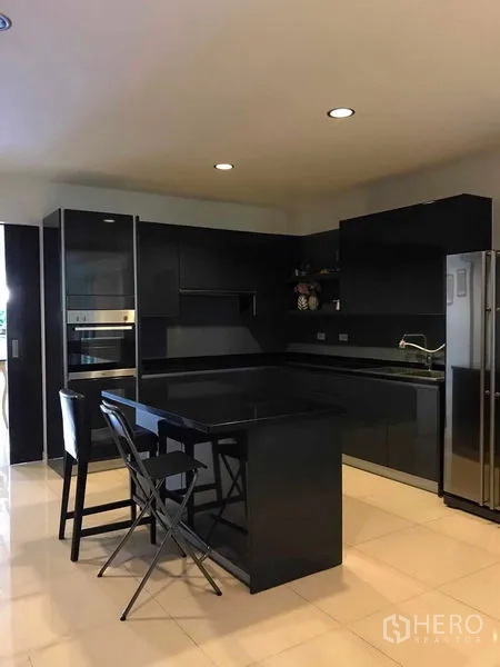 บ้าน ขายในWang Thonglang, Bangkok - ครัวโมเดิร์นสีดำพร้อมไอส์แลนด์ เตาอบ และตู้เย็นขนาดใหญ่