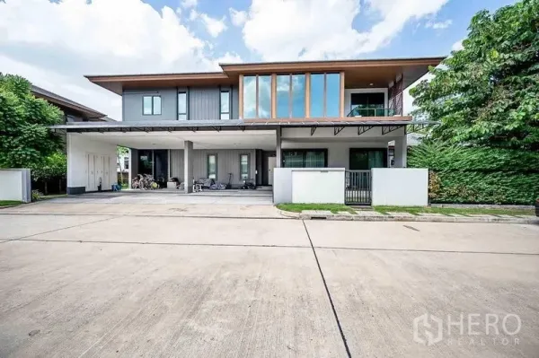 บ้าน ขายในPrawet, Bangkok - ด้านหน้าบ้านพร้อมโรงจอดรถกว้าง หน้าต่างสูง และประตูรั้วบนถนนเงียบสงบ.