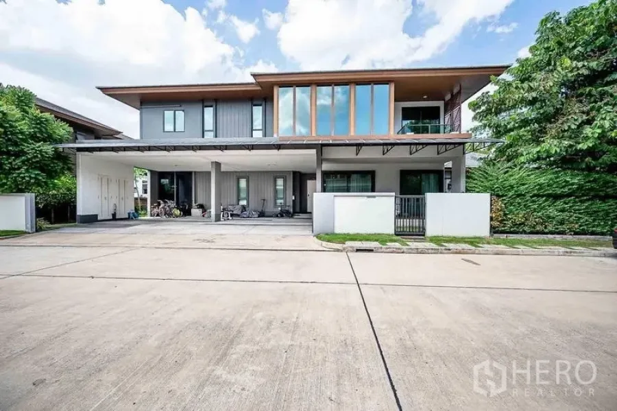 บ้าน ขายในPrawet, Bangkok - ด้านหน้าบ้านพร้อมโรงจอดรถกว้าง หน้าต่างสูง และประตูรั้วบนถนนเงียบสงบ.