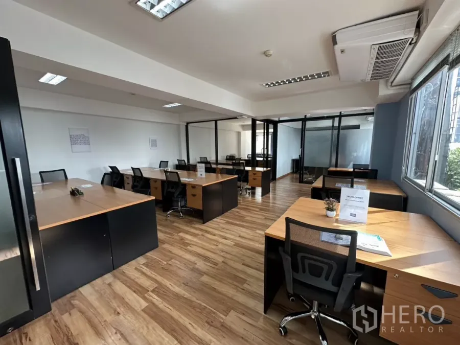 办公空间 出租在Watthana, Bangkok - 采光充足的开放式办公室，木纹地板，成排工位与玻璃会议室。